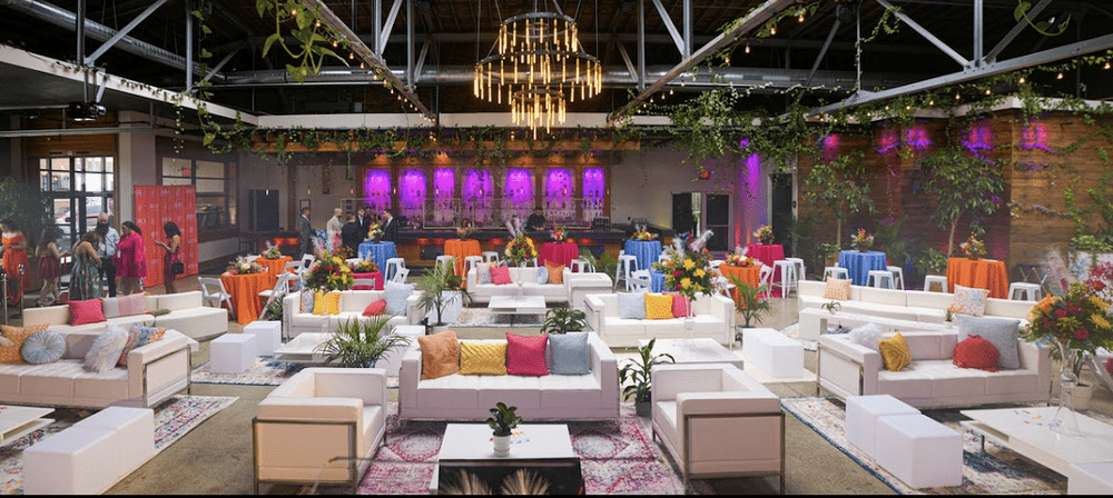 Rows of event seating with pink-lit staging at a BizBash event